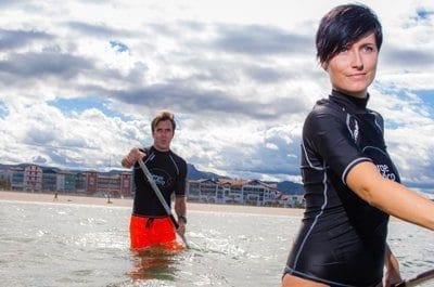 "Mensen doen Seawalk Paddle in de zee, genietend van de unieke buitensportervaring op Nederlandse stranden