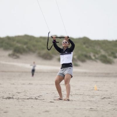 "Vrouw geniet van actieve strandactiviteit: powerkiten op het strand