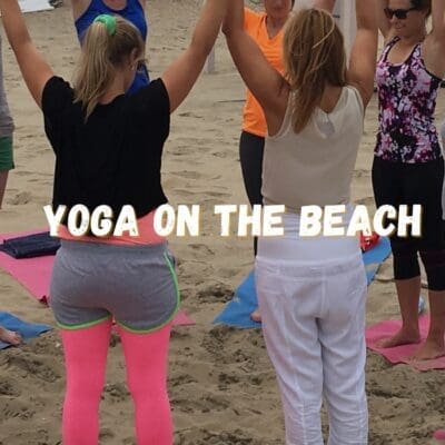 "Mensen beoefenen yoga op het strand, omringd door de zee en duinen, ervaren innerlijke rust en harmoniev